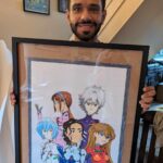 A happy customer holding a framed anime themed caricature by pen jones cartoons